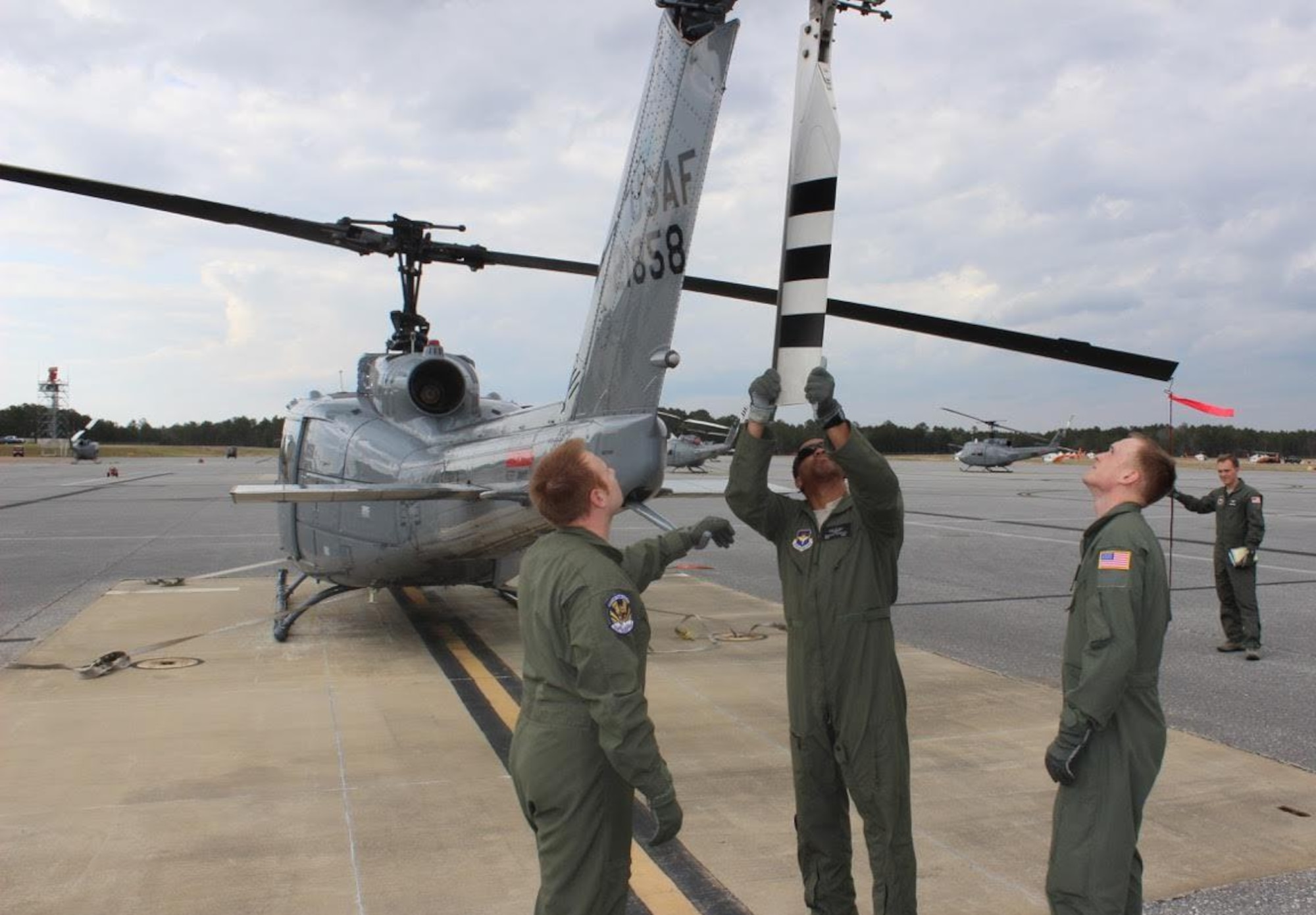 From left, Tech. Sgt. Adam Stubbs, flight chief with the 23rd Flying Training Squadron, instructs, Tech. Sgt. Brandon Harrison and Airman 1st Class Adam Flaucher, students, on preflighting the tail rotor of the TH-1H Huey prior to their first flight, while trainee Airman 1st Class Brandon Mathis, holds a lanyard tethered to the blade with a hook to the main rotor
to keep control of it. (U.S. Air Force photo by Tech. Sgt. Adam Davis) 
