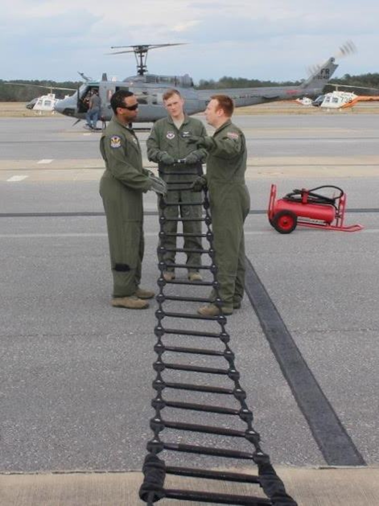 Tech. Sgt. Adam Stubbs, right, flight chief with the 23rd Flying Training Squadron, instructs the preflight inspection of a rope ladder alternate insertion/extraction device (AIE) to Tech. Sgt. Brandon Harris, left, and Airman 1st Class Adam Flaucher, center, both special missions aviators-in-training with the 23rd FTS. (U.S. Air Force photo by Tech. Sgt.
Adam Davis) 
