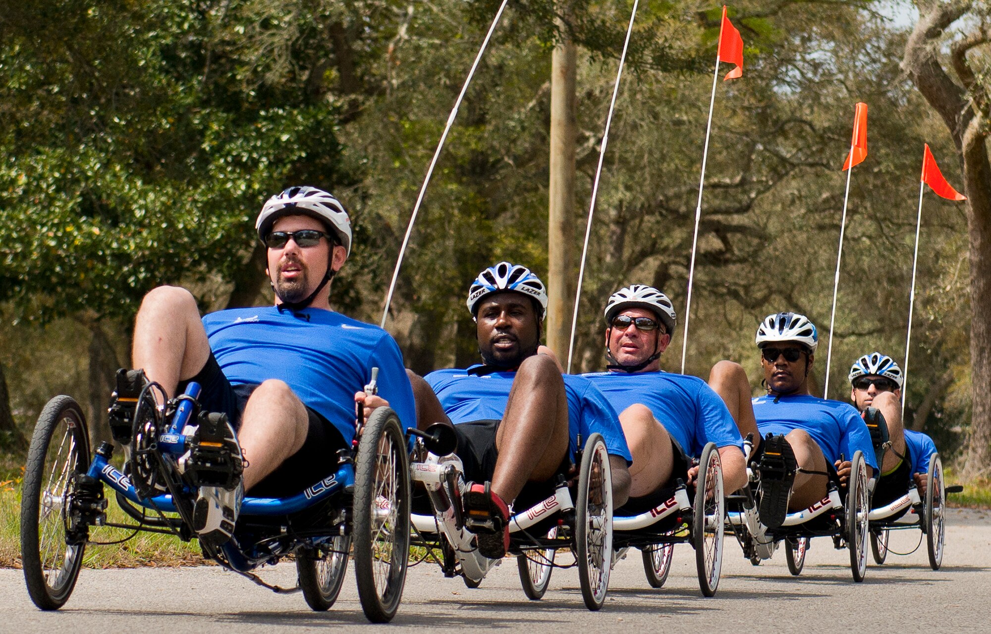 Warrior Care attendees on recumbent bikes form a line while riding during morning cycling session at the adaptive sports camp at Eglin Air Force Base, Fla., April 6. The base hosts the week-long Wound Warrior Care event that helps recovering wounded, ill and injured military members through specific hand-on rehabilitative training. (U.S. Air Force photo/Samuel King Jr.)
