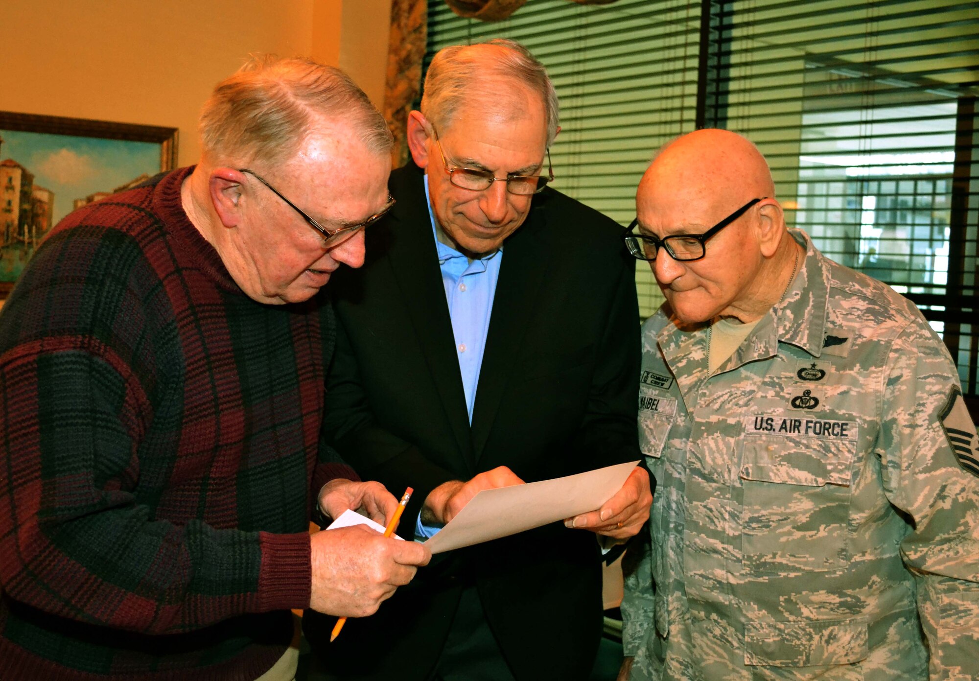From left to right, retired Col. Lou Meier, former 111th Fighter Wing commander; retired Lt. Col. Gary Yudell, former 111th FW O-2 Skymaster and A-37 Dragonfly pilot; and retired Master Sgt. Jim Waibel, currently a historian for the 111th Attack Wing at Horsham Air Guard Station, Pa. view and old photograph during the Wing’s 74th annual 111th Attack Wing Retirees Dinner in Philadelphia, April 4, 2016. The yearly dinner hosts retirees, current members and associated 111th Attack Wing staff for an evening of socialization between Pa. Air National Guard members. (U.S. Air Force photo by Tech. Sgt. Andria Allmond)