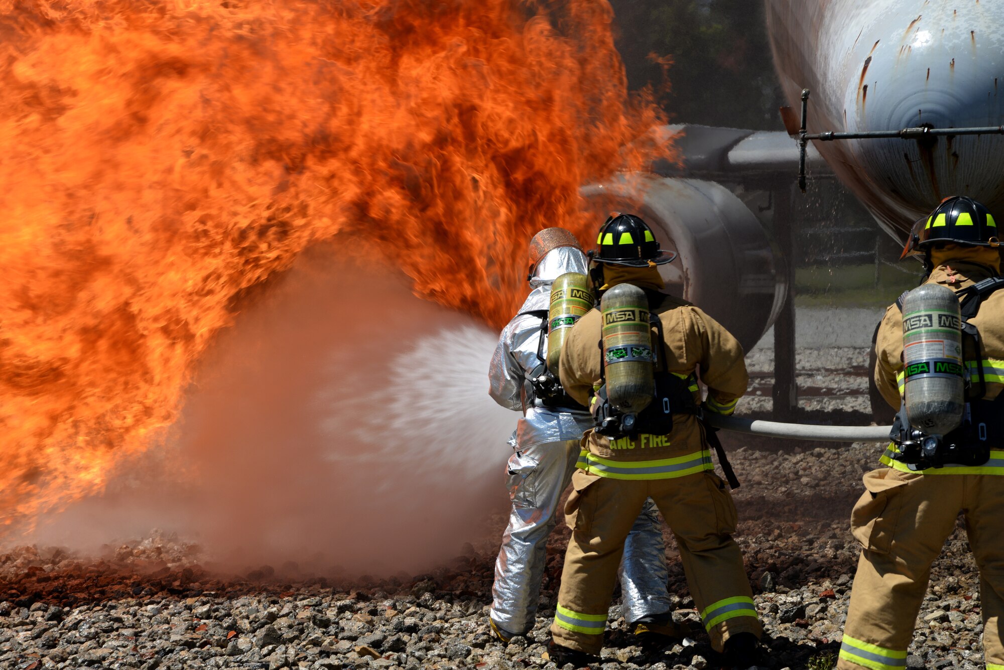 A picture of Airmen from Connecticut, Maine, New Jersey, Rhode Island and Vermont Air National Guard Fire Departments performing a live aircraft fire training exercise.