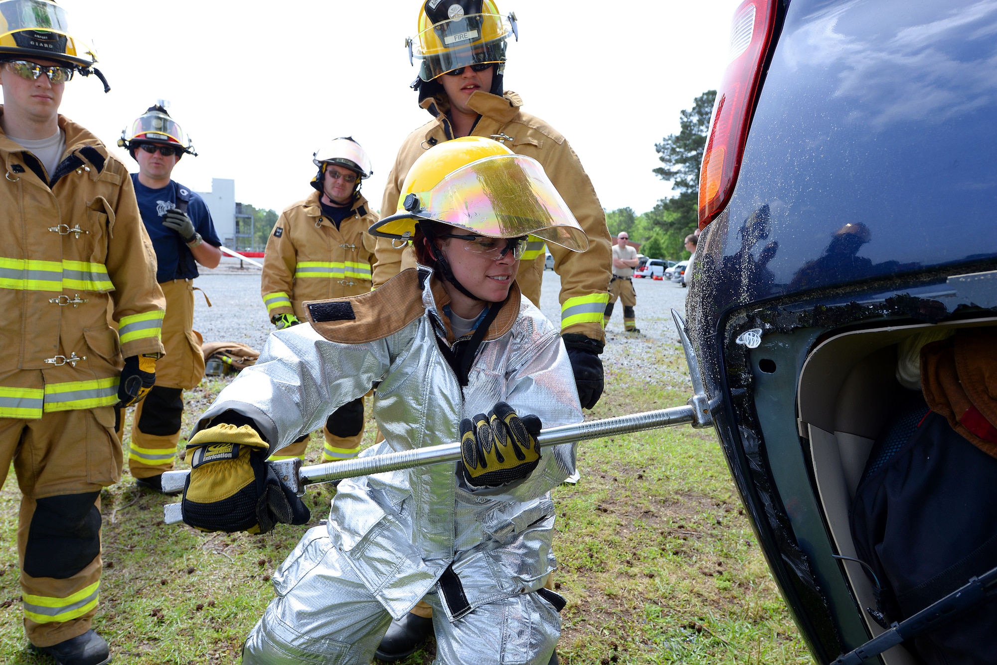 A picture of Airman 1st Class Brooke Hunt of the 177th Fighter Wing Fire Department, New Jersey Air National Guard, utilizing a halligan tool to soften a vehicle.