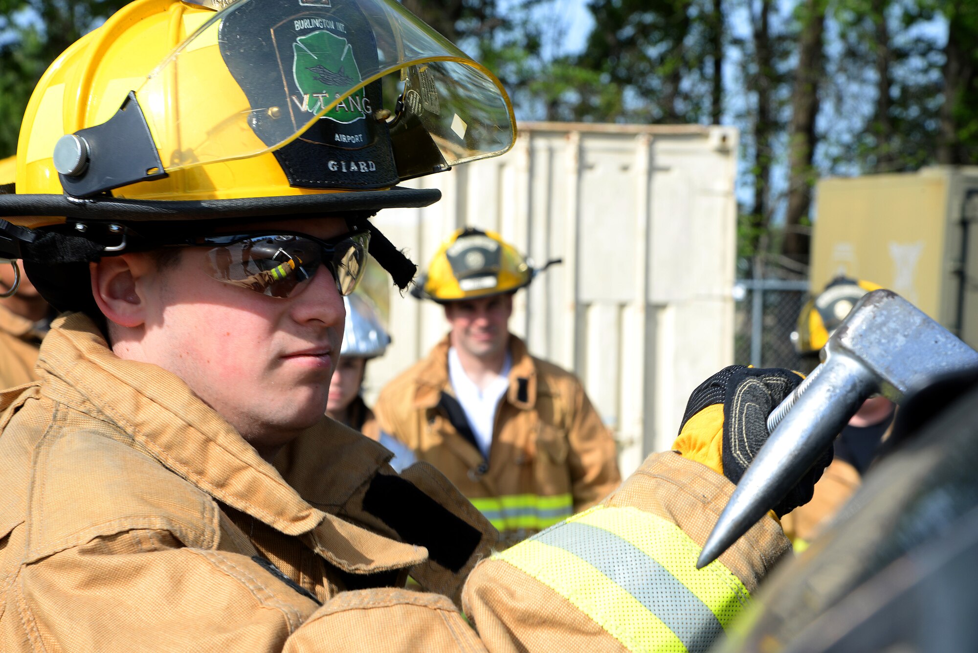 A picture of Airman 1st Class Evan Giard of the 158th Fighter Wing Fire Department, Vermont Air National Guard, utilizing a halligan tool to soften a vehicle.