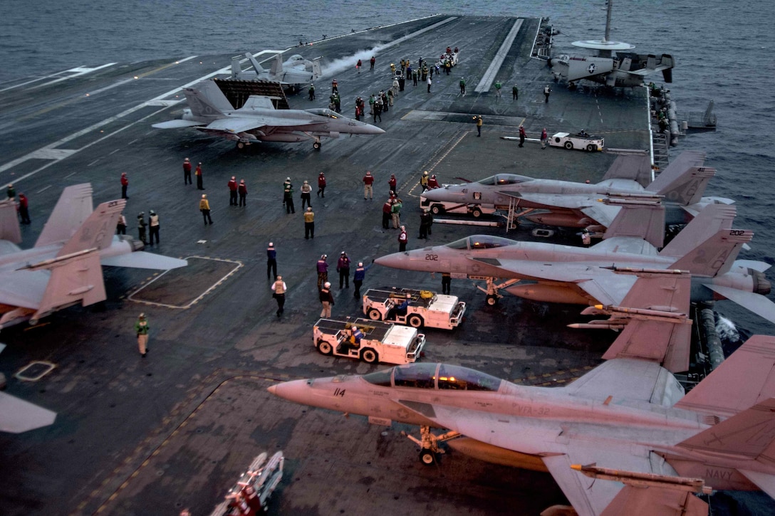 Sailors prepare to conduct night flight operations on the flight deck of the aircraft carrier USS Dwight D. Eisenhower in the Atlantic Ocean, March 25, 2016. The Eisenhower is conducting a unit training exercise to prepare for deployment. Navy photo by Petty Officer 3rd Class Anderson W. Branch