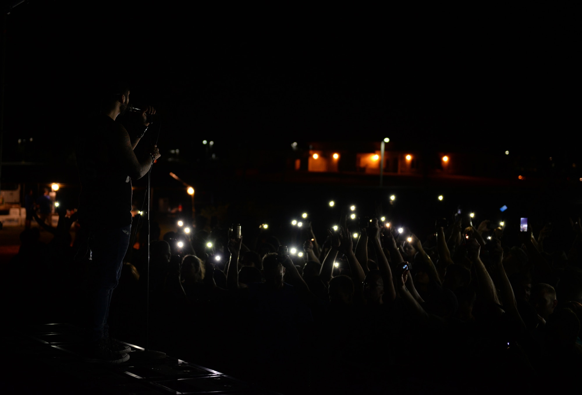 Fans turn on cellphone lights during the Drowning Pool concert April 6, 2016, at Andersen Air Force Base, Guam. In addition to the concert, Team Andersen members had the opportunity to meet with the band for autographs and photos. (U.S. Air Force photo by Airman 1st Class  Jacob Skovo)