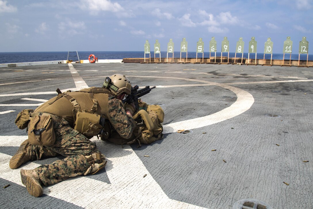 A Marine fires from a kneeling prone position during a deck shoot aboard the USS New Orleans in the Pacific Ocean, April 1, 2016. Marine Corps photo by Sgt. Hector de Jesus