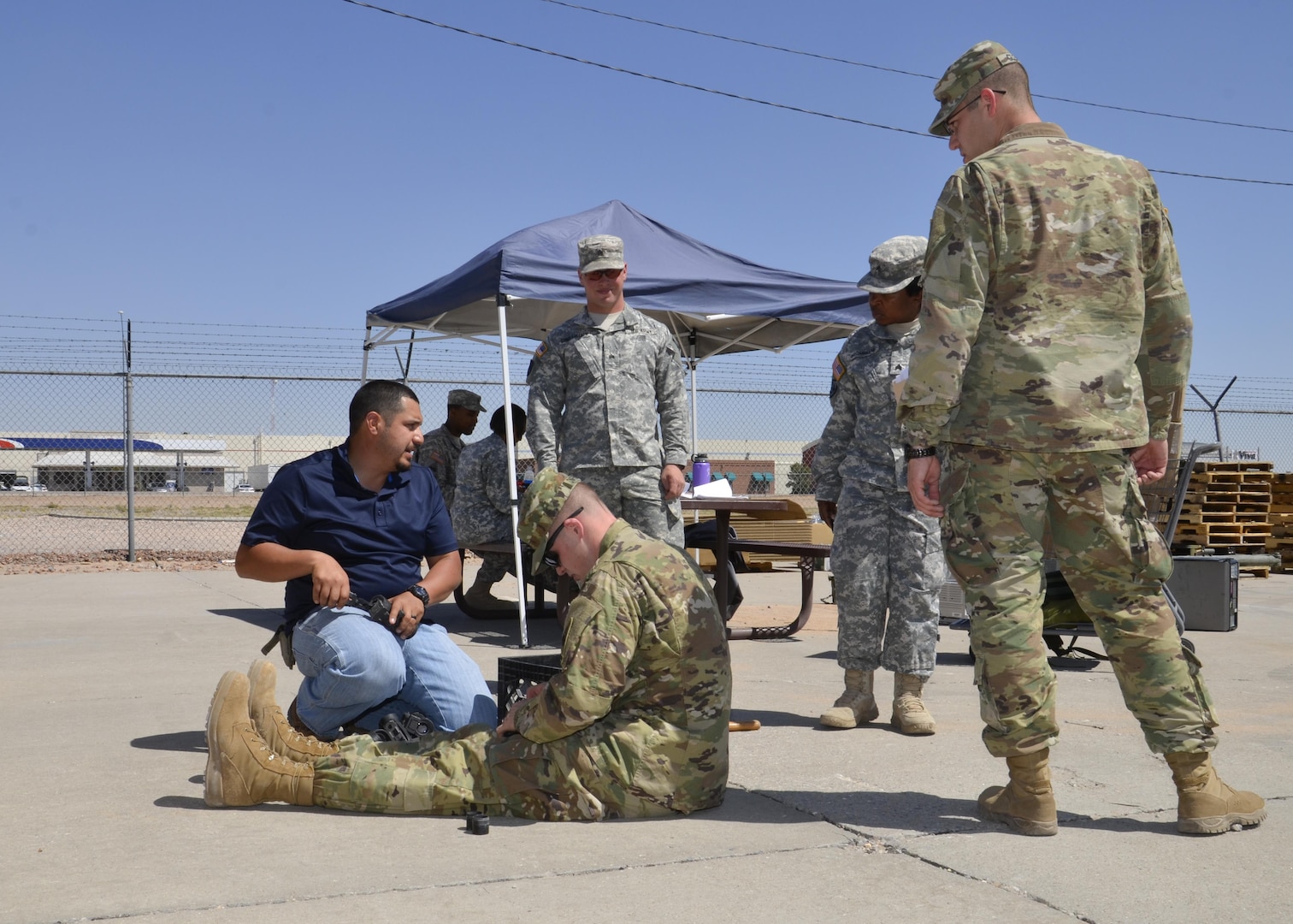 Ray Menendez (blue shirt) a material examiner at DLA Disposition Services Fort Bliss, Texas. Helps a solider with items he is turning in for disposal while soldiers from other units ask Menendez questions concerning the property they are turning in. 