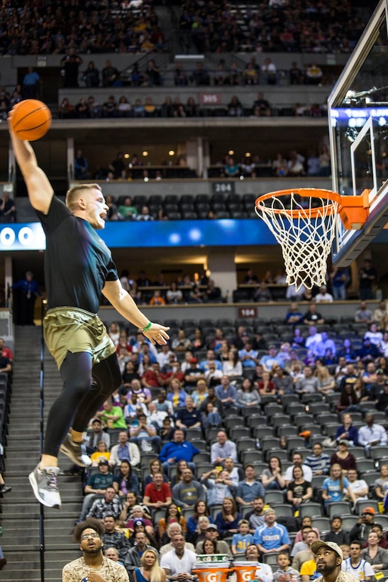 Sgt. Michael Oberley, a recruiter with Recruiting Sub-Station Pueblo, Recruiting Station Denver, performs a dunk during the Nuggets Military Appreciation Game at the Pepsi Center in Denver, CO April 2, 2016. The Nuggets incorporated personnel from all military branches during several events of the night, to include a future service member swear in.