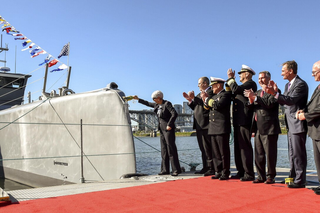 Deputy Defense Secretary Bob Work, second from left, celebrates during a Defense Advanced Research Projects Agency christening ceremony for a technology demonstration vessel in Portland, Ore., April 7, 2016. DARPA’s anti-submarine warfare continuous trail unmanned vessel program designed, developed and built the vessel. DoD photo by Army Sgt. 1st Class Clydell Kinchen