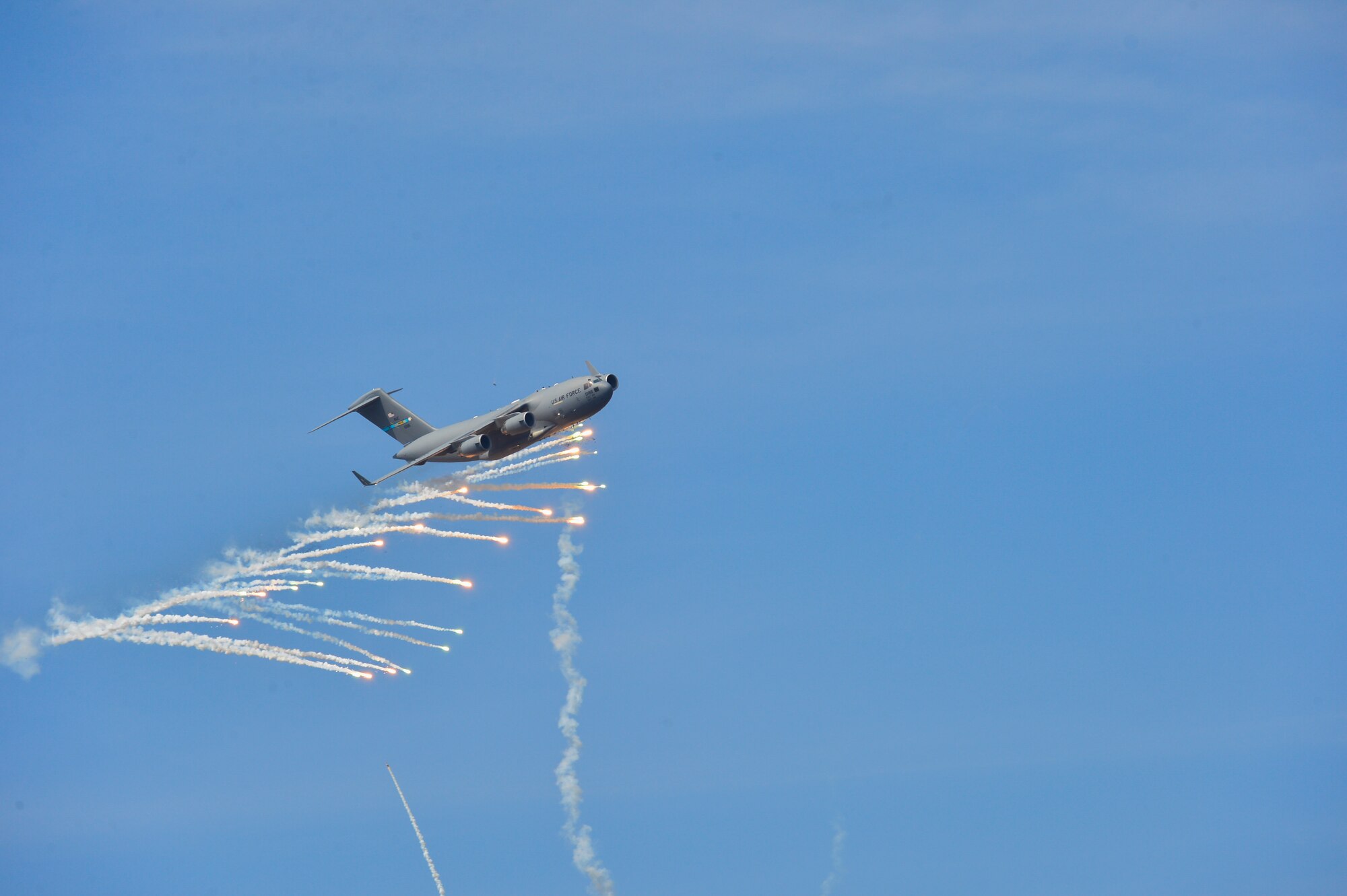 A C-17A Globemaster III from Dover Air Force Base, Del., expends countermeasure flares to defeat a simulated surface-to-air missile, or smokey SAM, shot from a Man-Portable Aircraft Survivability Trainer system during a training mission March 24, 2016, at the Bollen Live-Fire Range Complex on Fort Indiantown Gap, Pa. A total of 240 flares were expended for the aircraft during the training mission. (U.S. Air Force photo/Senior Airman William Johnson)