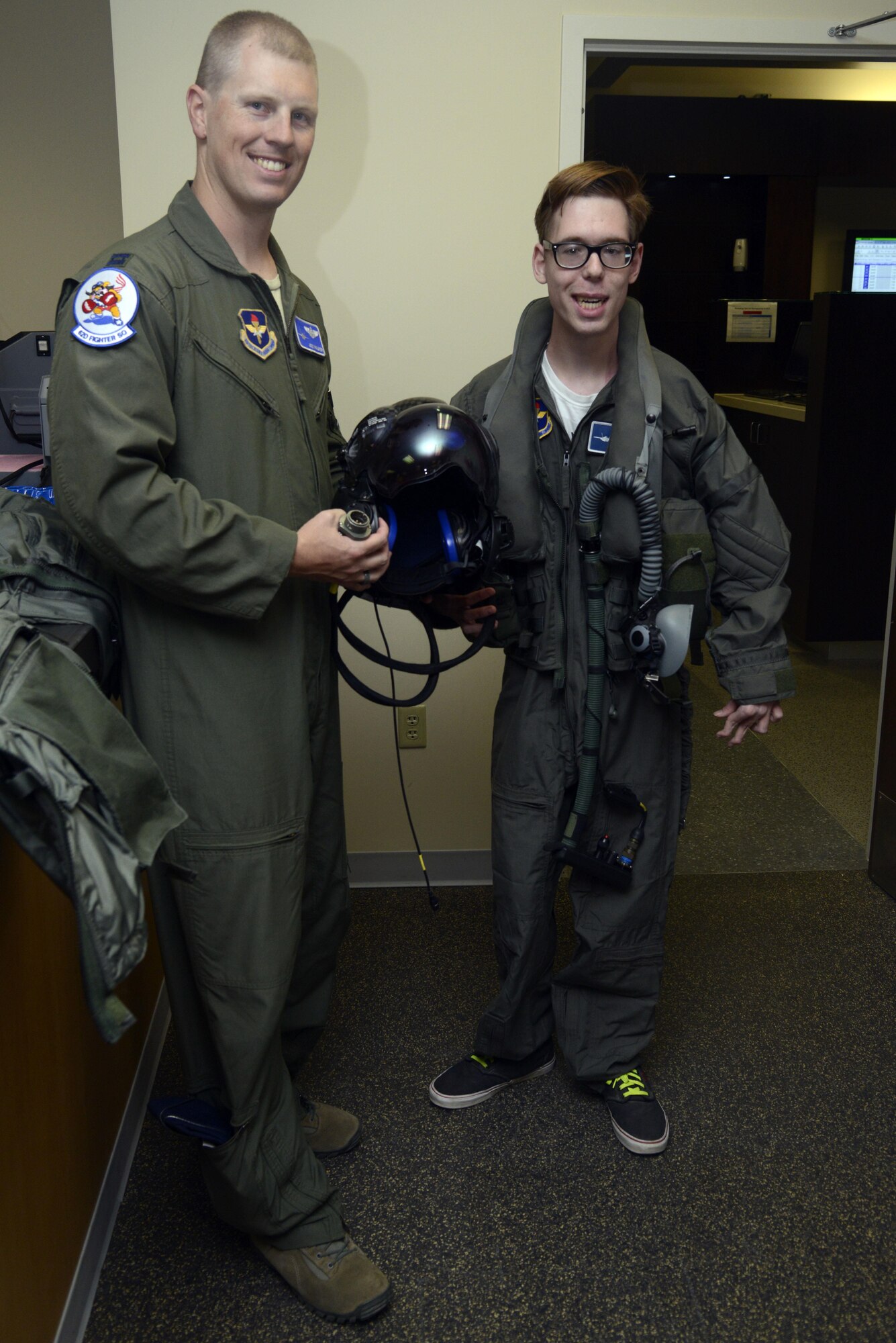 Capt. Joseph Walker, 62nd Fighter Squadron flight commander, and Zack "Z-man" Anderson, 16, pose with the F-35 helmet at Luke Air Force Base, Ariz., April 7, 2016. Anderson received the tour as part of the pilot for a day program, which provides children who have serious or chronic illnesses an opportunity to be part of a flying squadron for an entire day. (U.S. Air Force photo by Senior Airman Devante Williams) 