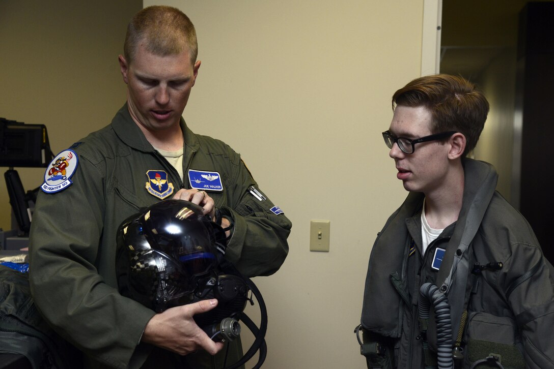 Capt. Joseph Walker, 62nd Fighter Squadron flight commander, shows Zach "Z-man" Anderson, 16, the F-35 pilot helmet during his tour of the 62nd Fighter Squadron at Luke Air Force Base, Ariz., April 7, 2016. Anderson received the tour as part of the pilot for a day program, which provides children who have serious or chronic illnesses an opportunity to be part of a flying squadron for an entire day. (U.S. Air Force photo by Senior Airman Devante Williams)