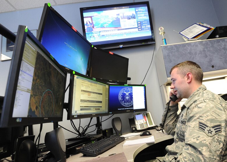 Senior Airman Dakota Powers, Air Force Rescue Coordination Controller, monitors computer screens while taking a phone call April 5 at the 601st Air Operations Center. The facility is staffed 24/7 to respond to, and coordinate rescue operations. (U.S. Air Force photo by Senior Airman Ty-Rico Lea/Released)