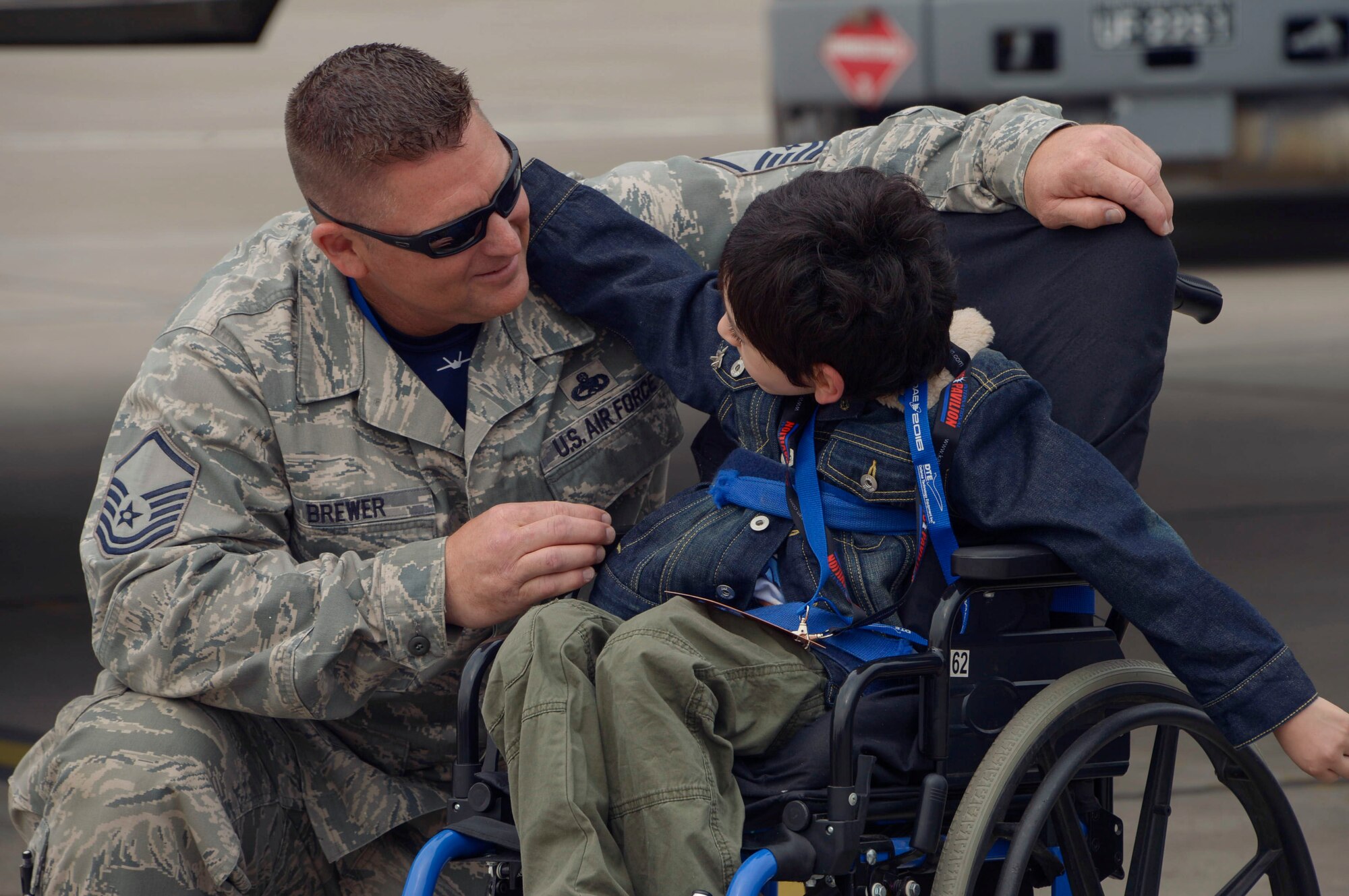 Master Sgt. Ambrose Brewer, F-22 Raptor Demonstration Team lead planner, talks to a child during the 2016 International Air and Space Fair (FIDAE) in Santiago, Chile, April 1, 2016. Airmen from around the U.S. came to Chile to participate in FIDAE 2016, from March 29– April 3.  During their stay, they made time to connect one-on-one with members of the community and hosted children from the Make-A-Wish and Teletón Foundations. (U.S. Air Force photo by Tech. Sgt. Heather Redman/Released)