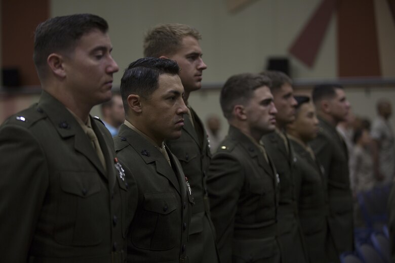 Basic Communications Officer Course 1-16 students stand at the position of attention during the playing of the national anthem during the course’s graduation ceremony at the base theater April 1, 2016. (Official Marine Corps Photo by Cpl. Julio McGraw/Released)