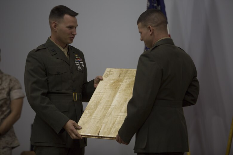 Captain Dimitri Stepanoff, executive officer, Communication Training Battalion, accepts a gift presented to him from students of the Basic Communications Officer Course 1-16 during the course’s graduation ceremony at the base theater April 1, 2016. (Official Marine Corps Photo by Cpl. Julio McGraw/Released)