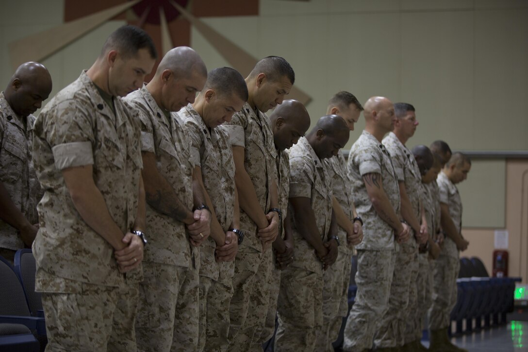 Marines from Communication Training Battalion’s Communications Chief Course 1-16 bow their heads during the invocation of the course’s graduation ceremony at the base theater April 1, 2016. The course provided the students with overall knowledge of equipment capabilities and system integration of all elements of transmission, telecommunication and information systems found throughout the Marine Corps. (Official Marine Corps photo by Cpl. Julio McGraw/Released)