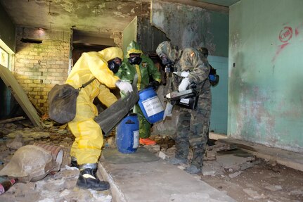 A combined assessment team was made up of two Spanish Army Recon Regt. Soldiers, one Spanish Emergency Military Unit member and U.S. Army Staff Sgt. Shawn McKenna, from the 7th Mission Support Command’s 773rd Civil Support Team, center, conduct a site assessment of a suspected chemical spill site inside an abandoned building spray painted with murals of graffiti and littered with brick, concrete and debris, Apr. 5, 2016.  U.S. Army Reserve Soldiers from the 7th MSC conducted combined joint partnered foreign consequence management disaster response operations with personnel from U.S. Navy Combined Joint Task Force 68 as part of more than 100 military members and civilians as part of the Combined Joint Task Force-Foreign Consequence Management or CJTF-FCM in support of the Spanish Emergency Military Unit first responders  or UME and Spanish Army Recon during disaster emergency response exercise Combined Joint Exercise SUR 2016.