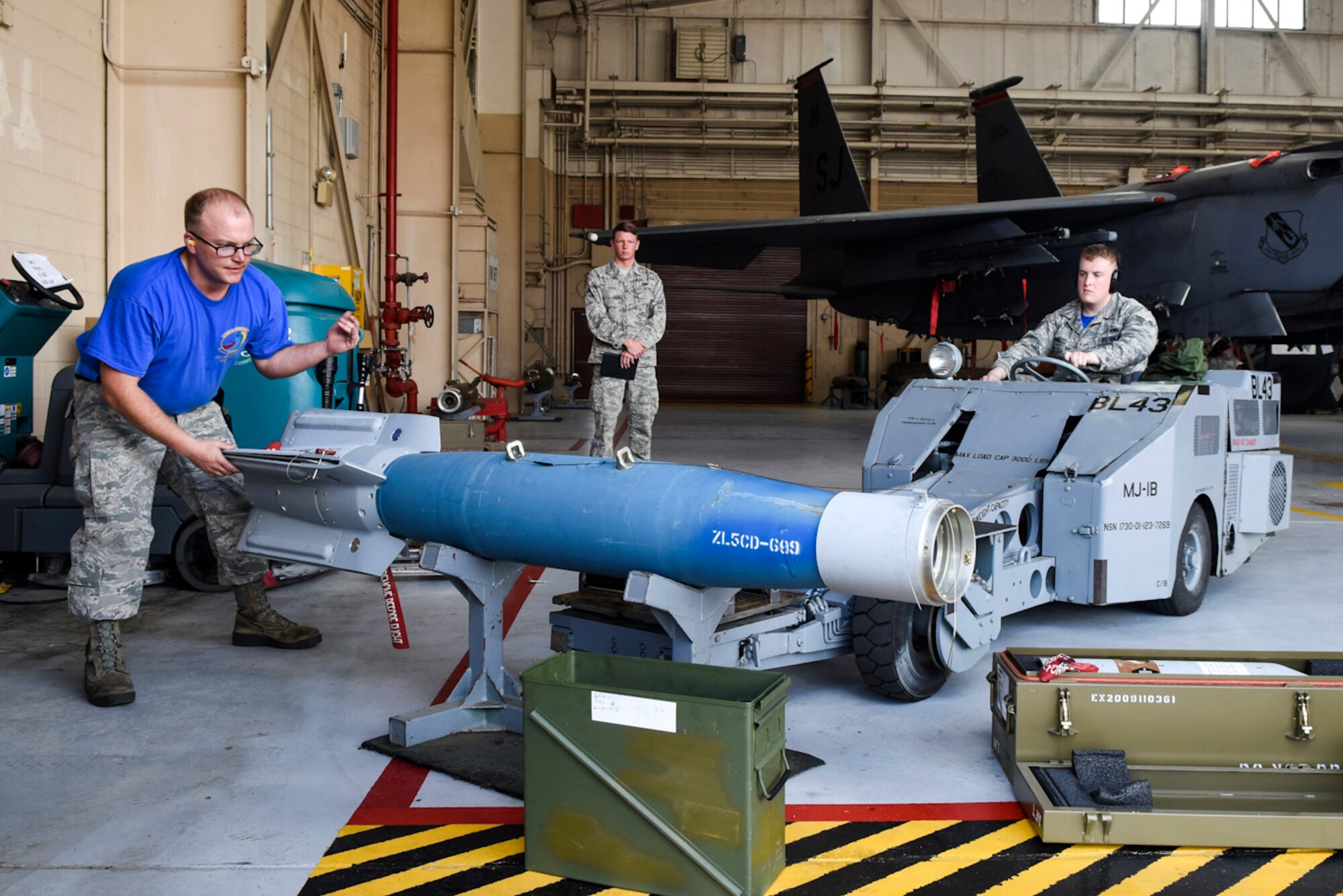 Staff Sgt. Travis Gregory (left), 4th Aircraft Maintenance Squadron load crew team chief, assists Senior Airman Dakota Edwards, 4th AMXS weapons load crew member, with loading a weapon during the Load Crew of the Quarter competition, April 7, 2016, at Seymour Johnson Air Force Base, North Carolina. Crews from the 4th AMXS compete every quarter to earn a spot in the top four to compete for the Load Crew of the Year. (U.S. Air Force photo/Airman Shawna L. Keyes)