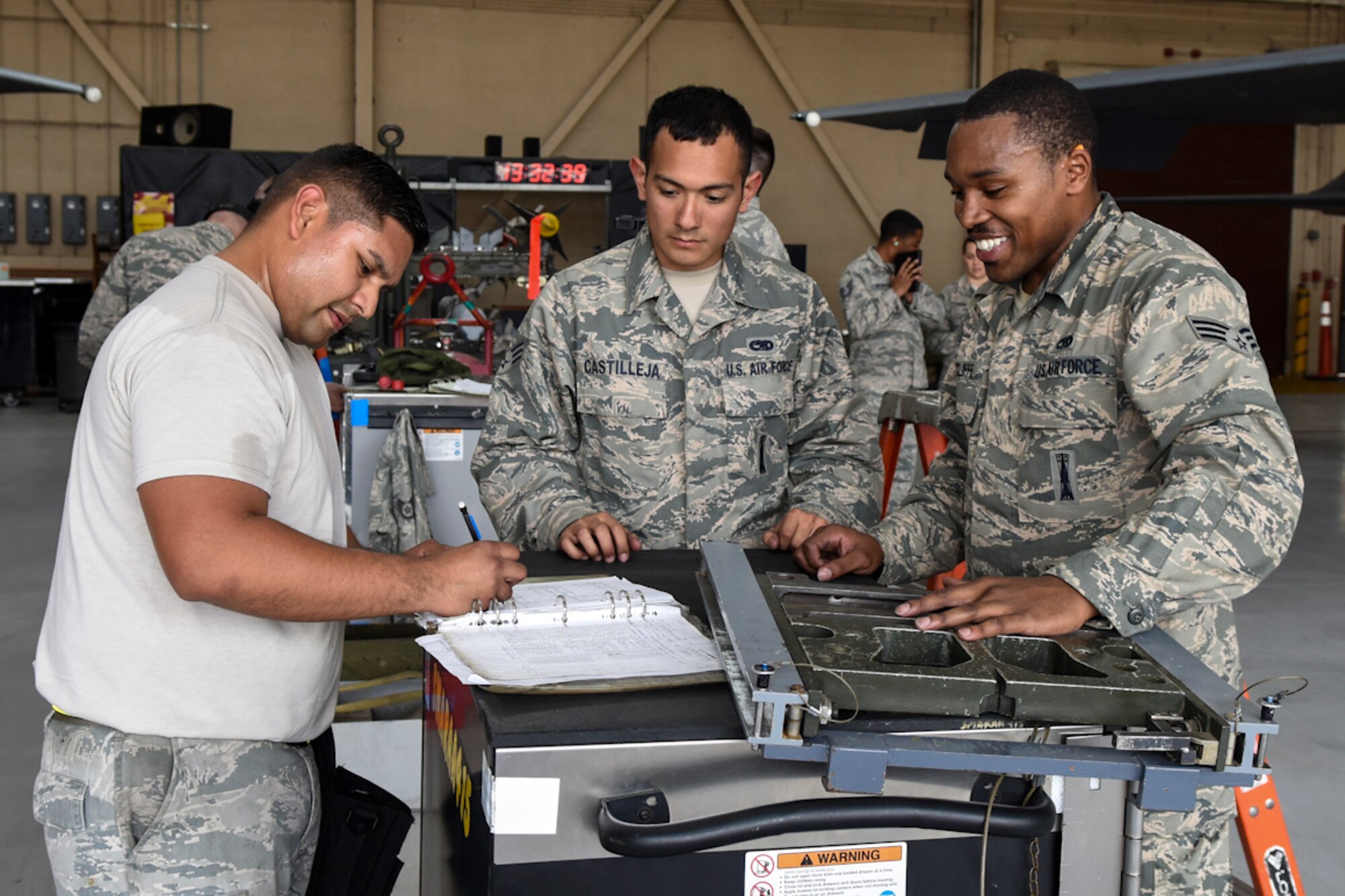 Staff Sgt. Ospicio Rodriguez (left), 4th Aircraft Maintenance Squadron load crew team chief, completes final checks while Senior Airmen Richard Castilleja (center) and John Ratcliffe (right), 4th AMXS load crew members, look on during a Load Crew of the Quarter competition, April 7, 2016, at Seymour Johnson Air Force Base, North Carolina. After final checks are complete time is stopped and final scoring is done by the judges. (U.S. Air Force photo/Airman Shawna L. Keyes)