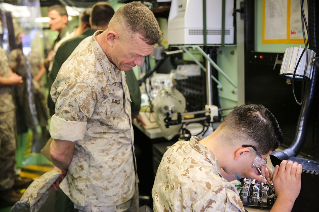 Lt. Gen. Jon Davis, deputy commandant of Marine Corps Aviation, watches a Marine with Marine Aviation Logistics Squadron (MALS) 16 work during the “Boots on the Ground” event aboard Marine Corps Air Station Miramar, Calif., April 5. “Boots on the Ground” allows senior leaders the opportunity to tour squadrons, meet with maintenance personnel and discuss how to better support aviation readiness requirements. (U.S. Marine Corps photo by Cpl. Alissa P. Schuning/Released)