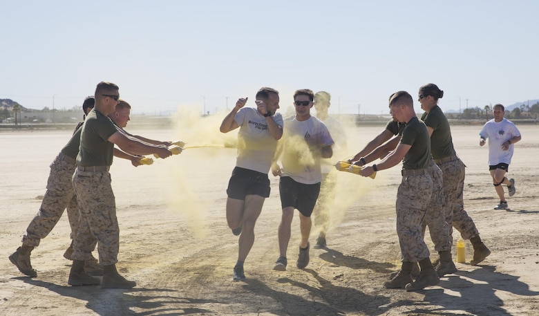 Participants of the Sexual Assault Prevention and Response annual Colorful Consent 5k Run are covered in colored powder while running through the five kilometer long course aboard the Combat Center, April 1, 2016. (Official Marine Corps photo by Cpl. Thomas Mudd/Released)