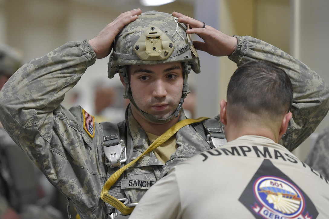 Army Staff Sgt. James Martell, right, ensures that Pfc. Alexander Sanchez is properly outfitted during a pre-jump gear inspection at the Joint Mobility Complex at Joint Base Elmendorf-Richardson, Alaska, March 31, 2016. Martell is a jumpmaster. Air Force photo by Alejandro Pena