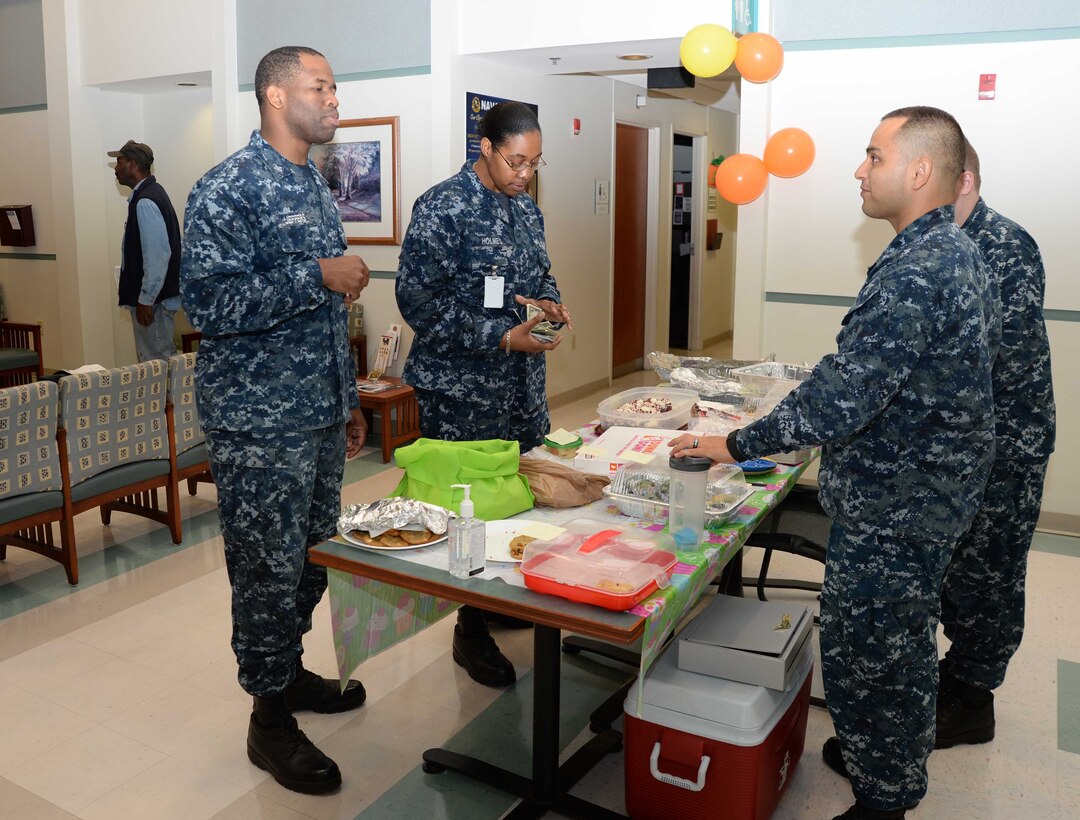 Petty Officer 1st Class Antresha Holmes (center) purchases items from a desserts table during a Navy-Marine Corps Relief Society’s Fund Drive bake sale, as Petty Officer 1st Class Kishaun Jeffers (left) looks on. The event, which was held at Naval Branch Health Clinic-Albany, aboard Marine Corps Logistics Base Albany, recently, was the final of three activities organized to raise money to assist military families in their time of unexpected, temporary crises. Petty Officer 3rd Class Louis Amaya Sanchez (right), laboratory technician, NBHC-Albany, is the clinic’s NMCRS representative/point of contact.