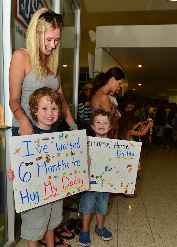 A family waits for their loved one to walk through the doors of the Joint Base Pearl Harbor-Hickam AMC Passenger Terminal after his six-month deployment, Joint Base Pearl Harbor-Hickam, April 5, 2016.(U.S. Air Force photo by Tech. Sgt. Aaron Oelrich/released) 