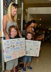 A family waits for their loved one to walk through the doors of the Joint Base Pearl Harbor-Hickam AMC Passenger Terminal after his six-month deployment, Joint Base Pearl Harbor-Hickam, April 5, 2016.(U.S. Air Force photo by Tech. Sgt. Aaron Oelrich/released) 