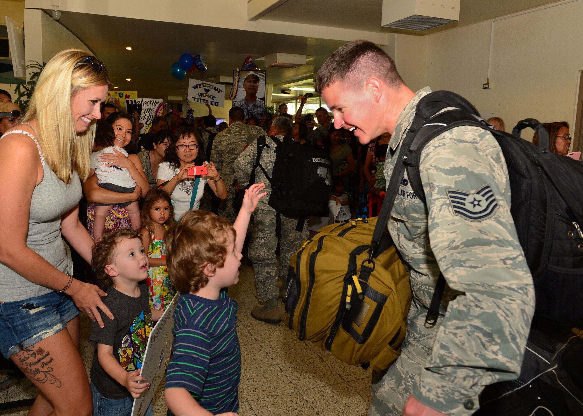 A Tech. Sgt. from the 154th Aircraft Maintenance Squadron greets his family after returning from a six-month deployment , on Joint Base Pearl Harbor-Hickam, , April 5, 2016.(U.S. Air Force photo by Tech. Sgt. Aaron Oelrich/released) 