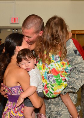 A Tech. Sgt. from the 154th Aircraft Maintenance Squadron, embraces his family after a six-month deployment, Joint Base Pearl Harbor-Hickam, April 5, 2016.(U.S. Air Force photo by Tech. Sgt. Aaron Oelrich/released) 