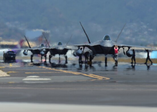 Airmen from the Hawaiian Raptors conduct an end of runway inspection of several F-22 Raptors as they return from a six-month deployment to the Central Command area of responsibility, Joint Base Pearl Harbor-Hickam, April 8, 2016. The Hawaiian Raptors are made up of F-22 pilots from the 199th Fighter Squadron and the active-duty 19th Fighter Squadron and are supported by the Hawaii Air National Guard’s 154th Maintenance Squadron and the active-duty 15th Maintenance Squadron. This marked the first operational deployment for the Hawaiian Raptors. (U.S. Air Force photo by Tech. Sgt. Aaron Oelrich/released)  