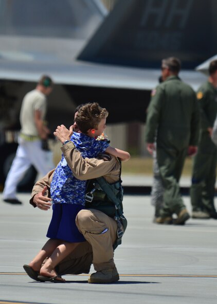 A boy greets his father, a F-22 pilot from the Hawaiian Raptors, for the first time in six months, on Joint Base Pearl Harbor-Hickam, April 8, 2016. The F-22 pilot returned home after a six-month deployment to the Central Command area of responsibility with the Hawaiian Raptors.  The Hawaiian Raptors are made up of F-22 pilots from the 199th Fighter Squadron and the active-duty 19th Fighter Squadron and are supported by the Hawaii Air National Guard’s 154th Maintenances Squadron and the active-duty 15th Maintenance Squadron. This marked the first operational deployment for the Hawaiian Raptors. (U.S. Air Force photo by Tech. Sgt. Aaron Oelrich/released) 