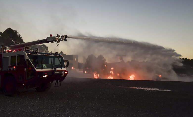 Firefighters with the 1st Special Operations Civil Engineer Squadron extinguish a fire during a firefighting exercise at Hurlburt Field, Fla., April 5, 2016.  During the exercise firefighters tested their proficiency on extinguishing exterior and interior fires on a simulated C-130 aircraft. (U.S. Air Force photo by Staff Sgt. Christopher Callaway) 