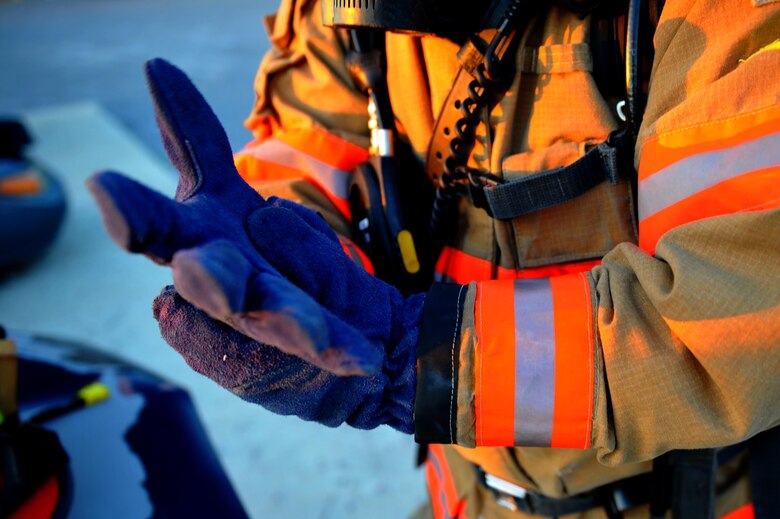 Douglas Woods, a firefighter with the 1st Special Operations Civil Engineer Squadron, puts on his gloves before a firefighting exercise at Hurlburt Field, Fla., April 4, 2016. Hurlburt Field firefighters transform training and exercise throughout the year to remain ready for emergency responses. (U.S. Air Force photo by Airman 1st Class Joseph Pick)