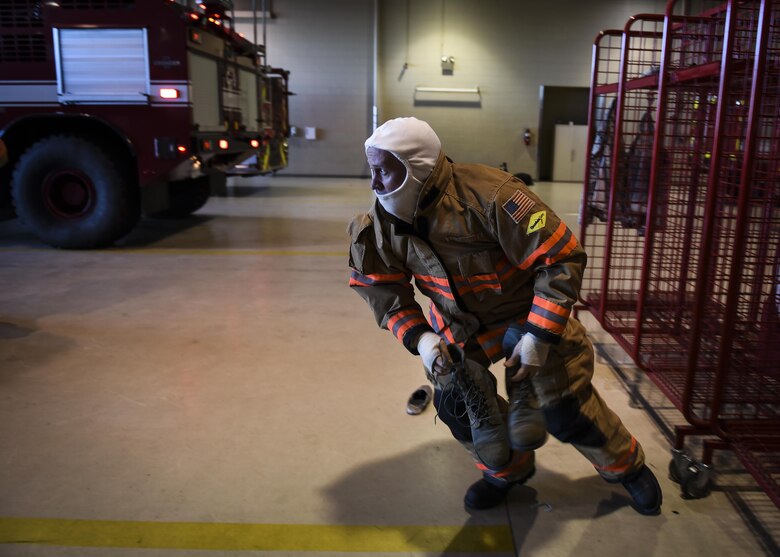 A firefighter with the 1st Special Operations Civil Engineer Squadron rushes to an emergency vehicle during a firefighting exercise at Hurburt Field, Fla., April 5, 2016. Hurlburt Field firefighters have less than a minute to don their gear and leave the station with the required emergency vehicles. (U.S. Air Force photo by Staff Sgt. Christopher Callaway) 