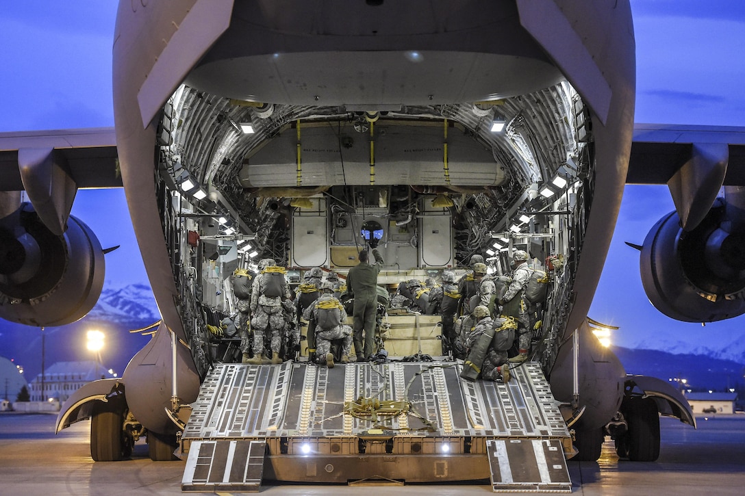 Paratroopers board and position their gear inside an Air Force C-17 Globemaster III aircraft before participating in a night jump at Joint Base Elmendorf-Richardson, Alaska, March 31, 2016. Air Force photo by Alejandro Pena