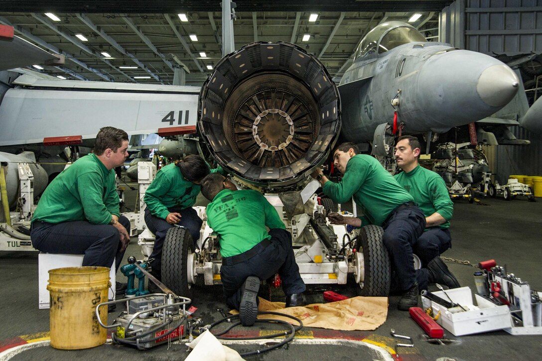 Sailors maintain a jet engine in the hangar bay of the aircraft carrier USS Dwight D. Eisenhower in the Atlantic Ocean, April 6, 2016. The aircraft carrier Eisenhower is conducting a Composite Training Unit Exercise to prepare for a future deployment. The sailors are assigned Strike Fighter Squadron 86. Navy photo by Seaman Casey S. Trietsch.