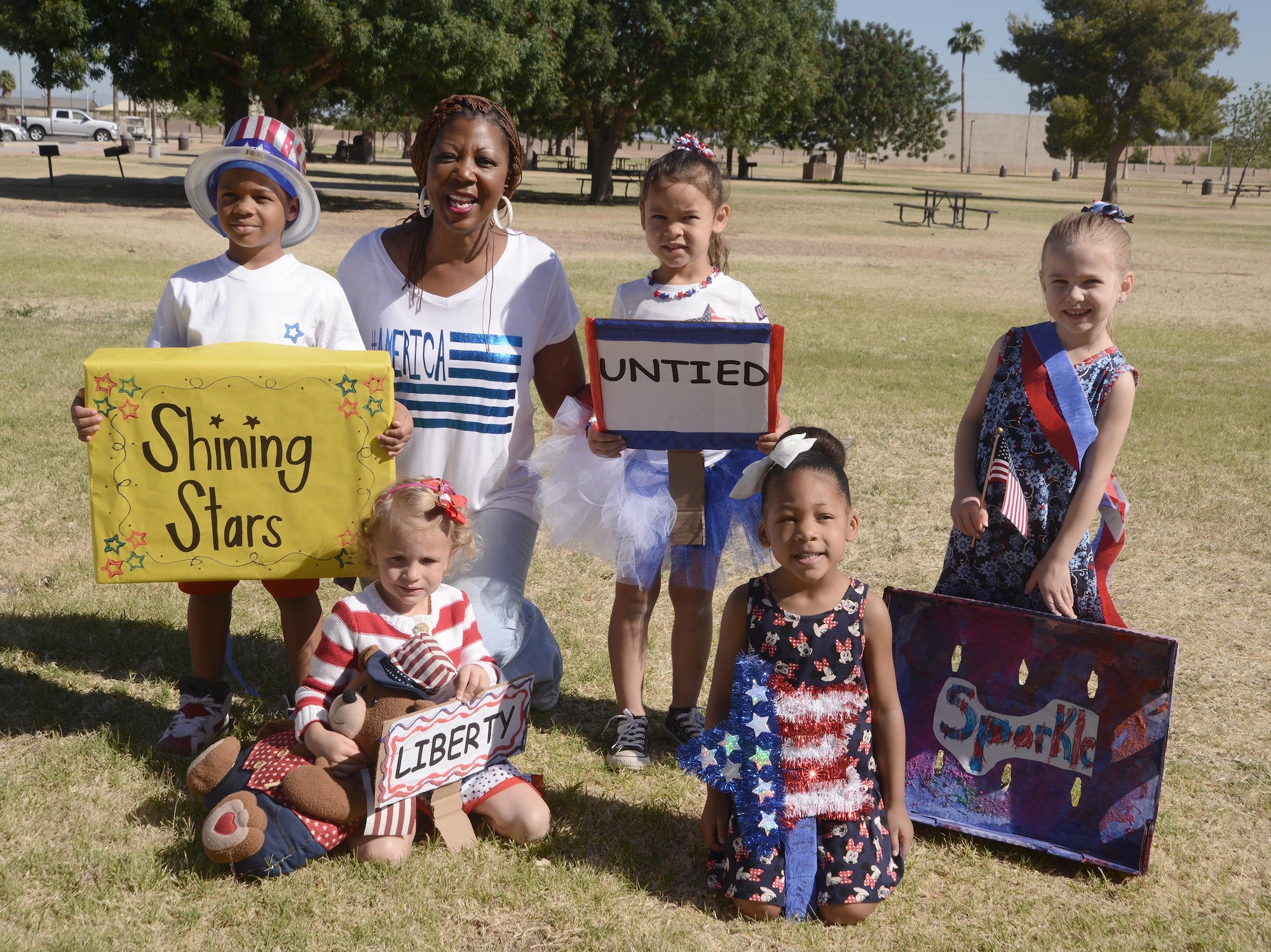 Ms. Dyane Robinson, Child Development Center Education Tech Supervisor, takes a group photo April 1, 2016, at Fowler Park on Luke Air Force Base, Arizona with Luke children who represented the four Pre-school classes that participated in this year’s kick-off parade. The Month of the Military Child honors the role that children play in the Armed Forces community. (U.S. Air Force photo by Denise Willhite) 