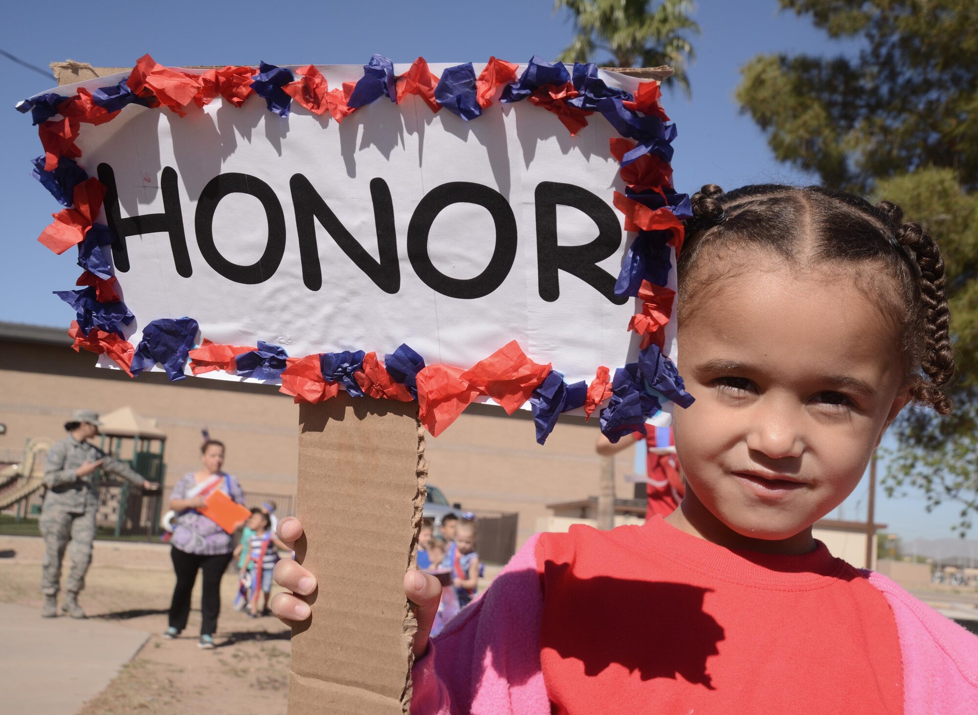 Gianna Brown, 4, daughter of Senior Master Sgt. Donnie Brown, 56th Force Support Squadron and Master Sgt,Tiffany Alteri-Brown, 56th Maintenance Group, holds up an “Honor” sign while participating in this year’s Month of the Military Child kick-off parade April 1, 2016 at Fowler Park on Luke Air Force Base, Arizona. Throughout the month, Luke children are taught that all lives matter, to be tolerant with each other and to respect and care for each other. (U.S. Air Force photo by Denise Willhite)  