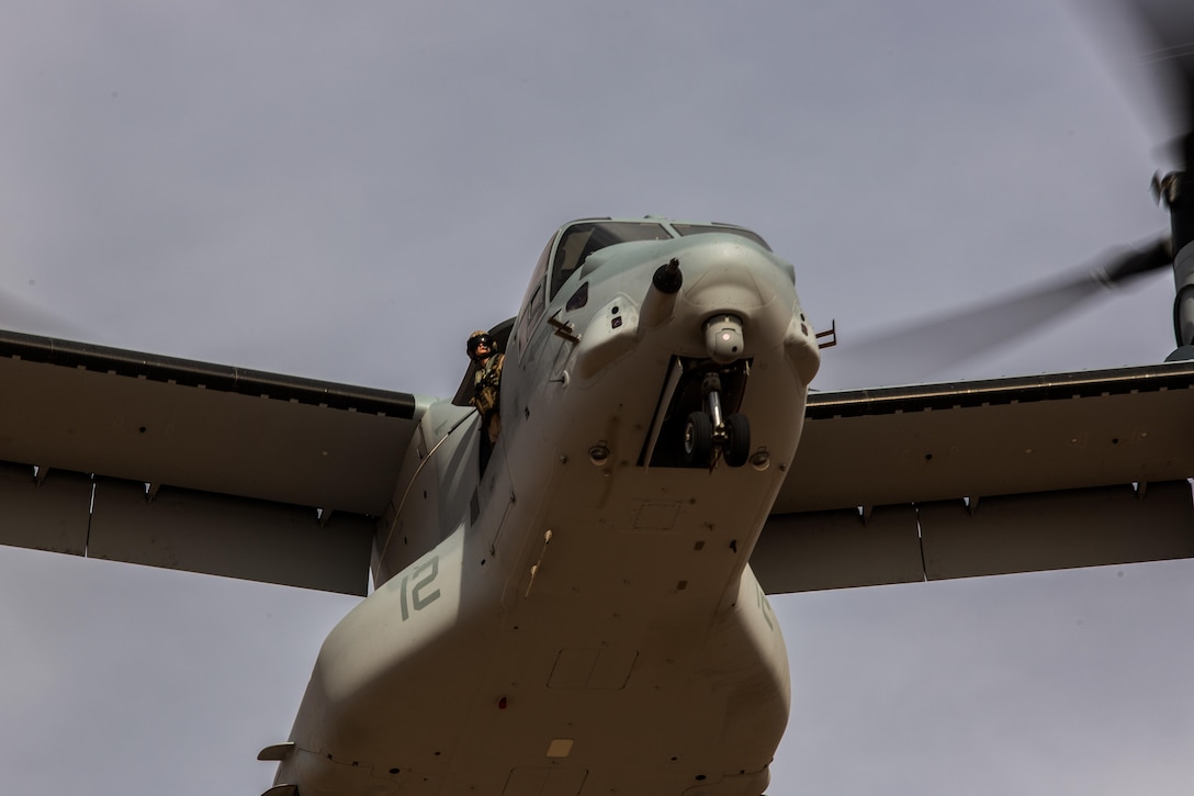 A crew chief with Marine Medium Tiltrotor Squadron (VMM) 165 “White Knights” looks out of a window aboard an MV-22B Osprey while conducting a confined area landing in Southern California, April 5. Each aircraft had at least two crew chiefs who acted as extensions of the pilots eyes and communicated the presence of potential hazards, the distance and location or nearby aircraft and the Osprey’s approximate distance from the ground. (U.S. Marine Corps photo by Sgt. Lillian Stephens/Released)