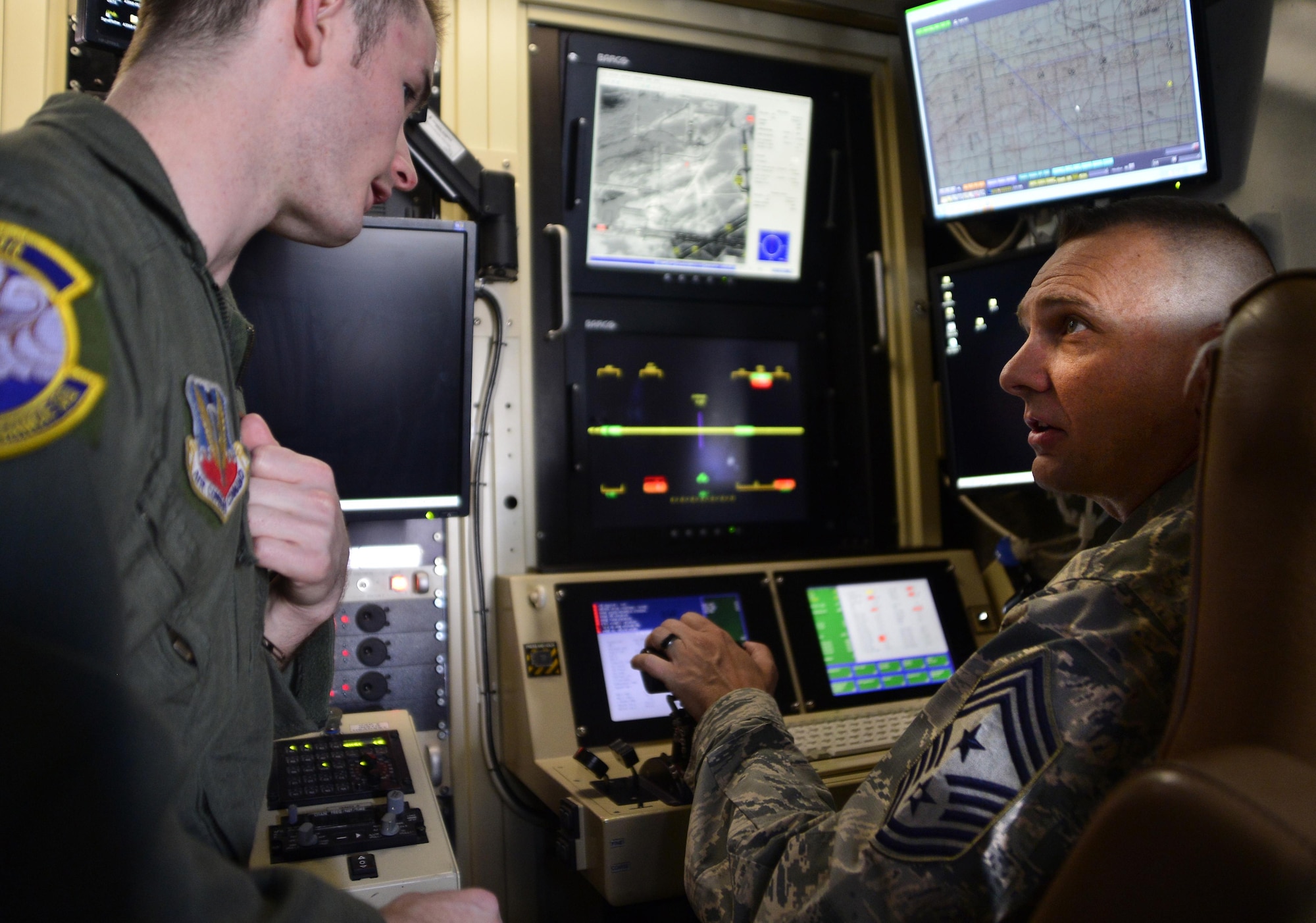 Senior Airman Jacob, 22nd Reconnaissance Squadron sensor operator, explains his job to Chief Master Sgt. Michael Ditore, 432nd Wing/432nd Air Expeditionary Wing command chief April 1, 2016 at Creech Air Force Base, Nevada. Jacob showed the chief how a sensor operator completes the mission by operating the multi-spectral targeting system. (U.S. Air Force photo by Senior Airman Christian Clausen/Released)