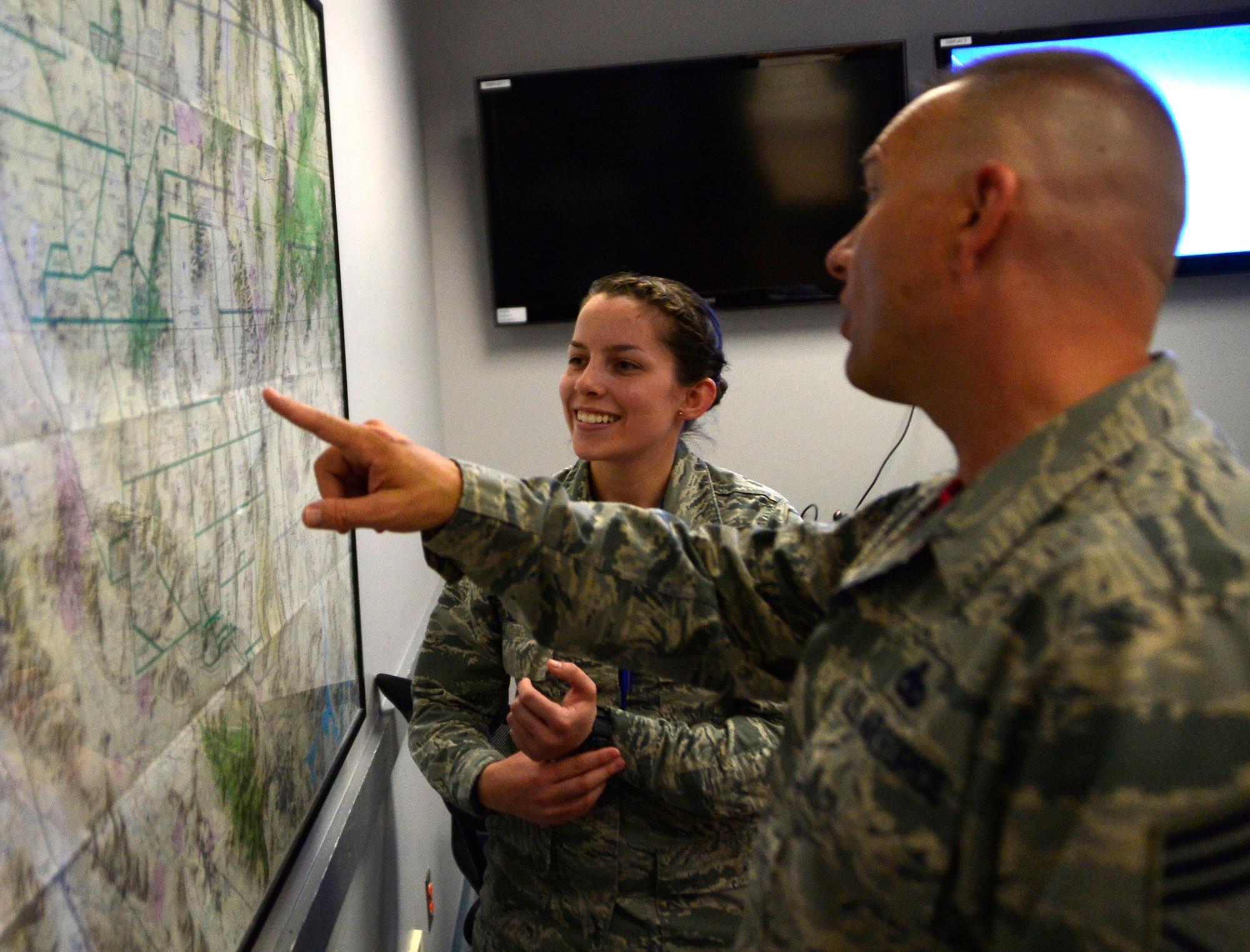 Senior Airman Nicole, 22nd Reconnaissance Squadron mission support analyst (MSA), explains how MSAs use maps to collect information needed for pre-flight briefings to Chief Master Sgt. Michael Ditore, 432nd Wing/432nd Air Expeditionary Wing command chief April 1, 2016 at Creech Air Force Base, Nevada. Nicole explained how the chief actively listened, asked questions and really cared about what the Airmen do for the mission and how they're doing in their personal lives. (U.S. Air Force photo by Senior Airman Christian Clausen/Released)