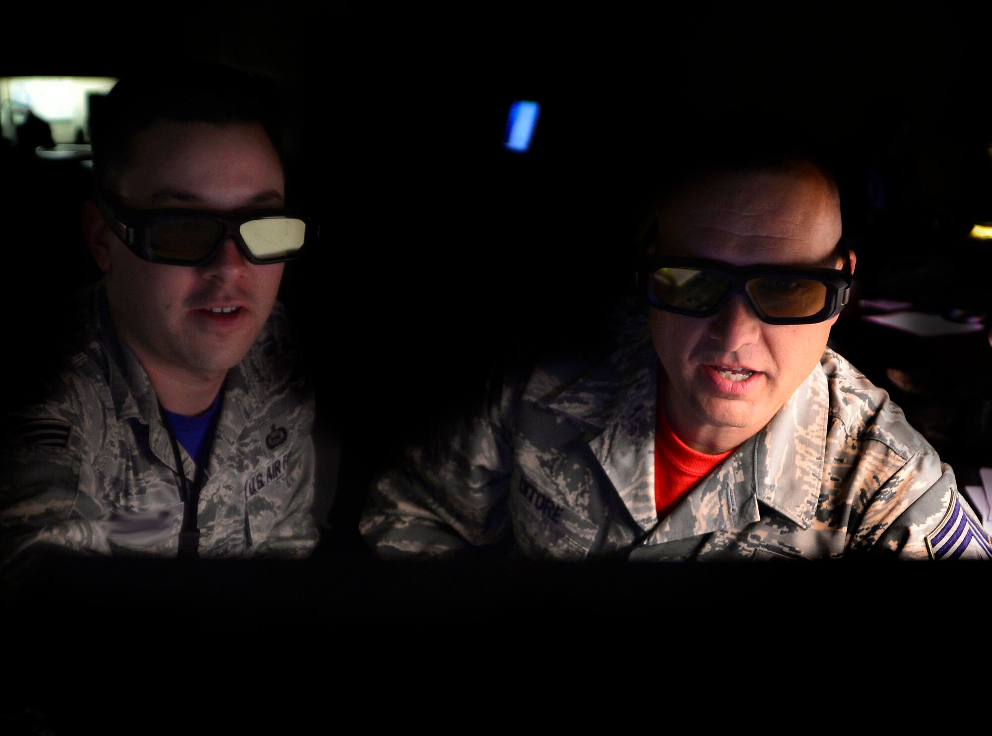 Staff Sgt. Andrew, 22nd Reconnaissance Squadron geospatial intelligence target coordinator, explains how targeteers use 3-D glasses to Chief Master Sgt. Michael Ditore, 432nd Wing/432nd Air Expeditionary Wing command chief April 1, 2016 at Creech Air Force Base, Nevada. Targeteers use the 3-D glasses to better identify which weapons should be used on a specific target. (U.S. Air Force photo by Senior Airman Christian Clausen/Released)