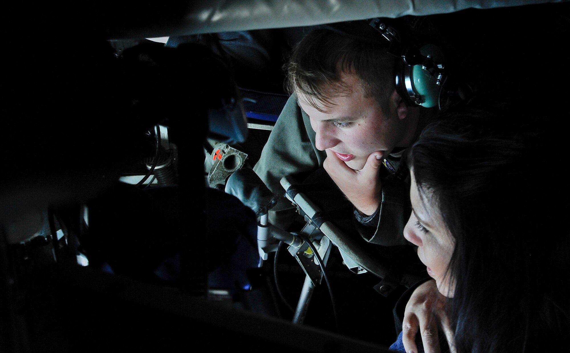 Senior Airman Darian Edwards, a boom operator with the 91st Air Refueling Squadron, left, answers questions and talks to a military spouse, right, about the boom during a spouse familiarization flight off the East Coast, April 6, 2016. The flight gave spouses of the 6th Air Mobility Wing an opportunity to see firsthand how Airmen enable the aerial refueling mission. (U.S. Air Force photo by Airman 1st Class Mariette Adams)