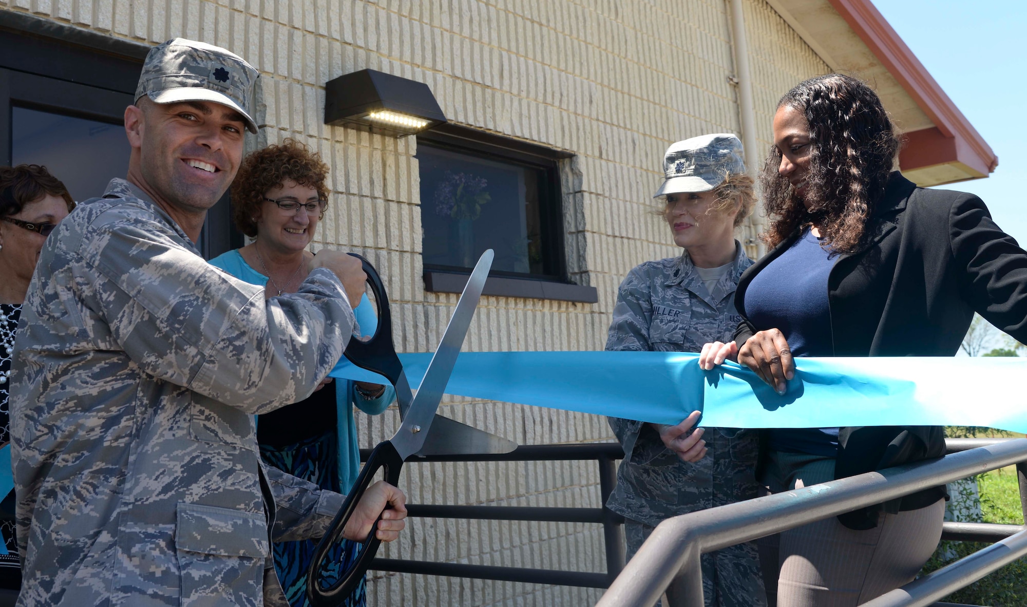 Lt. Col. Gregory Pleinis, director of staff with the 6th Wing Staff Agency, cuts the ceremonial ribbon during the Sexual Assault Prevention and Response (SAPR) Office ribbon cutting ceremony at MacDill Air Force Base, Fla., April 7, 2016. The ceremony was held to celebrate the SAPRO’s relocation. (U.S. Air Force photo by Senior Airman Vernon L. Fowler Jr.)