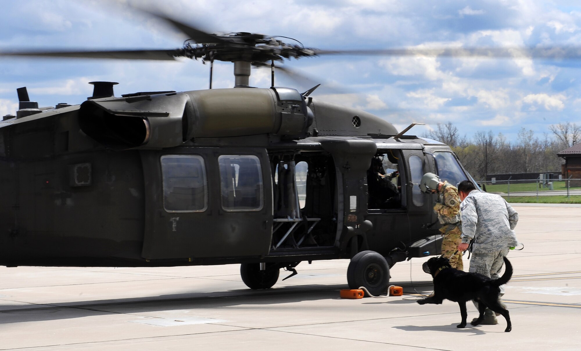 U.S. Air Force Staff Sgt. Ki Seung Nam, a 509th Security Forces Squadron military working dog (MWD) handler, runs toward a UH-60 Black Hawk helicopter with MWD Buda for an orientation flight at Whiteman Air Force Base, Mo., April 1, 2016. The 1-135th Attack Reconnaissance Battalion trains with the 509th Security Forces Squadron’s MWDs and their handlers for search and rescue or other operations that would require the MWDs to be air lifted. (U.S. Air Force photo by Airman 1st Class Michaela R. Slanchik)