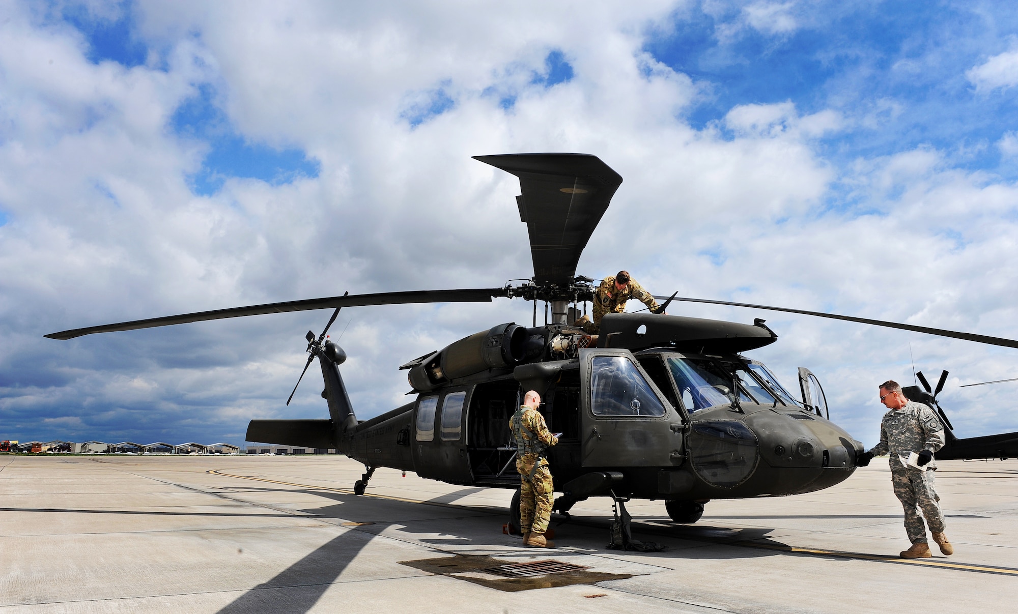 Missouri Army National Guard Staff Sgt. Brandon Isabell, a crew chief, left, Chief Warrant Officer 4 Marcus Moore, a standardization instructor pilot, middle, and Chief Warrant Officer 5 Robert Moore, a standardization instructor pilot, all assigned to the 1-135th Attack Reconnaissance Battalion Army Aviation Support Facility #1, perform pre-takeoff inspections on a UH-60 Black Hawk at Whiteman Air Force Base, Mo., April 1, 2016. The Black Hawk is a utility helicopter capable of performing search and rescue operations and medical evacuations, and carrying external loads, cargo and passengers. (U.S. Air Force photo by Airman 1st Class Michaela R. Slanchik)