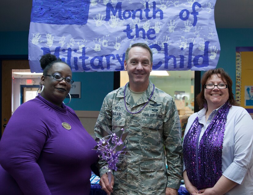 Chandre Coleman, JBA Child Development Center Three director, Col. Bradley Hoagland, 11th Wing and Joint Base Andrews commander, and Sharon Iniarte, JBA CDC Three assistant director, pose for a picture at a “purple” parade at JBA CDC Three April 7, 106. The parade kicks off Month of the Military Child, a time to honor military youth for the important role they play in contributing to the strength of the military family. (U.S. Air Force photo by Airman 1st Class Rustie Kramer/Released)
